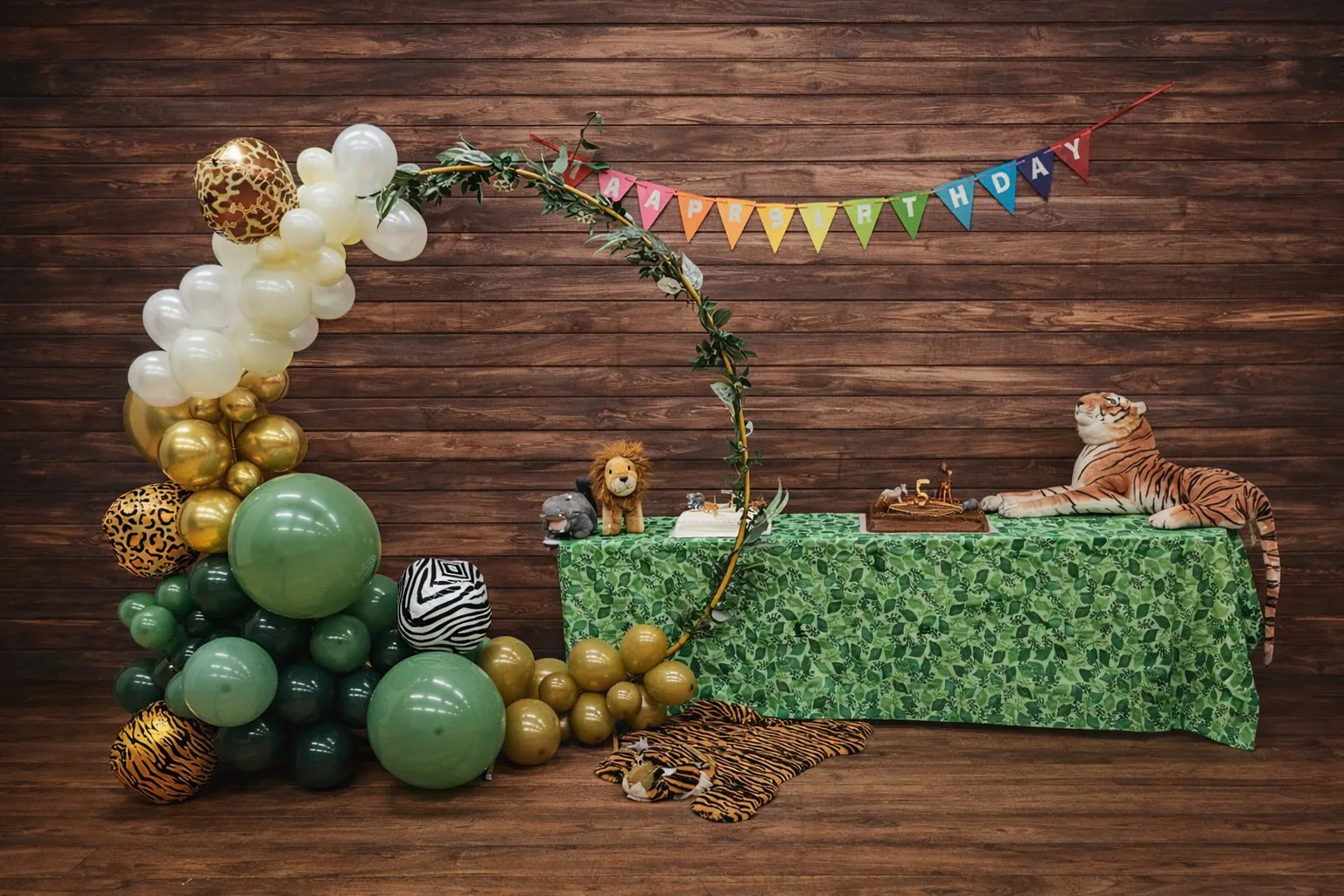 Jungle safari first birthday with sage and gold hoop arch and animal-print accents